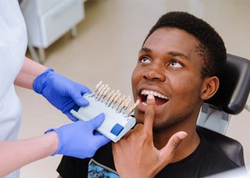 Person pointing to a tooth in their mouth