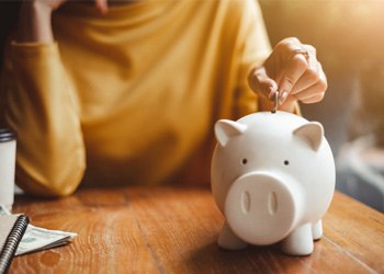 Person putting money in a piggy bank