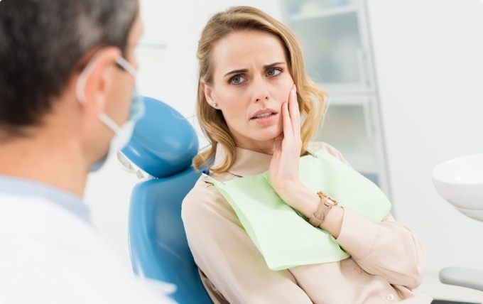 Woman with mouth pain talking to her emergency dentist in Moorestown
