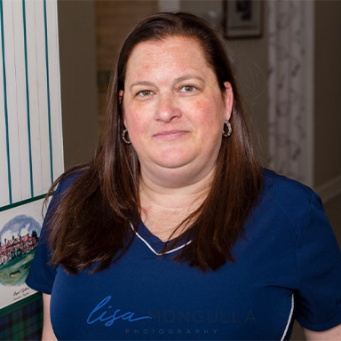 Smiling dental team member sitting at desk