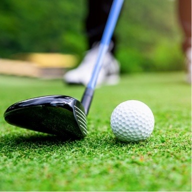 Golf club next to a golf ball on the ground