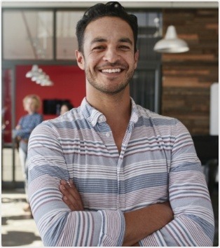 Man in striped shirt smiling in an office