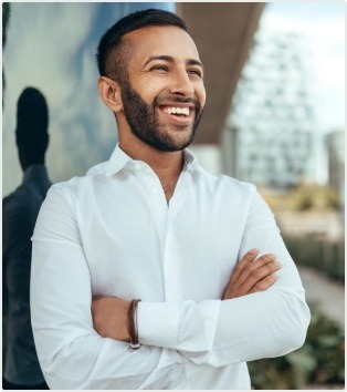 Man in white collared shirt smiling and standing with arms crossed