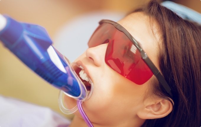 Girl receiving fluoride treatment in dental office