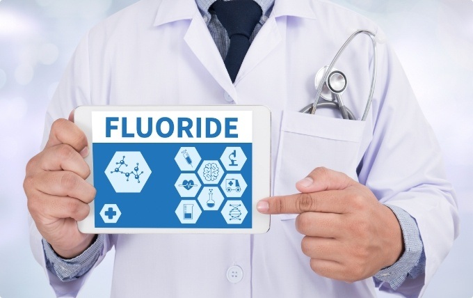 Dentist pointing to tablet screen that says fluoride